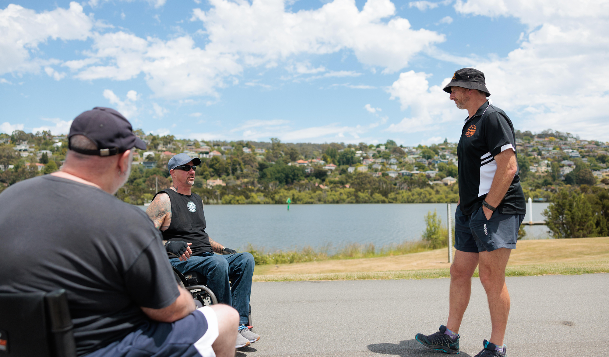 tamar Men chatting by riverside on sunny day